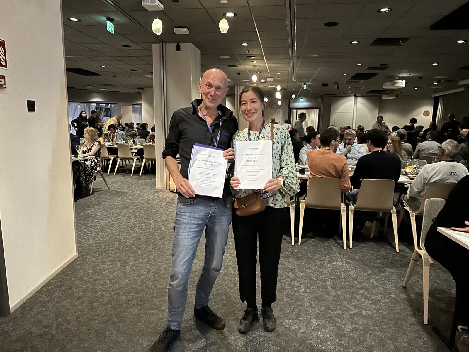 Maarten Marx (pictured left) receives the Best Short Paper Award at TPDL2025 on Floris Bos' behalf
